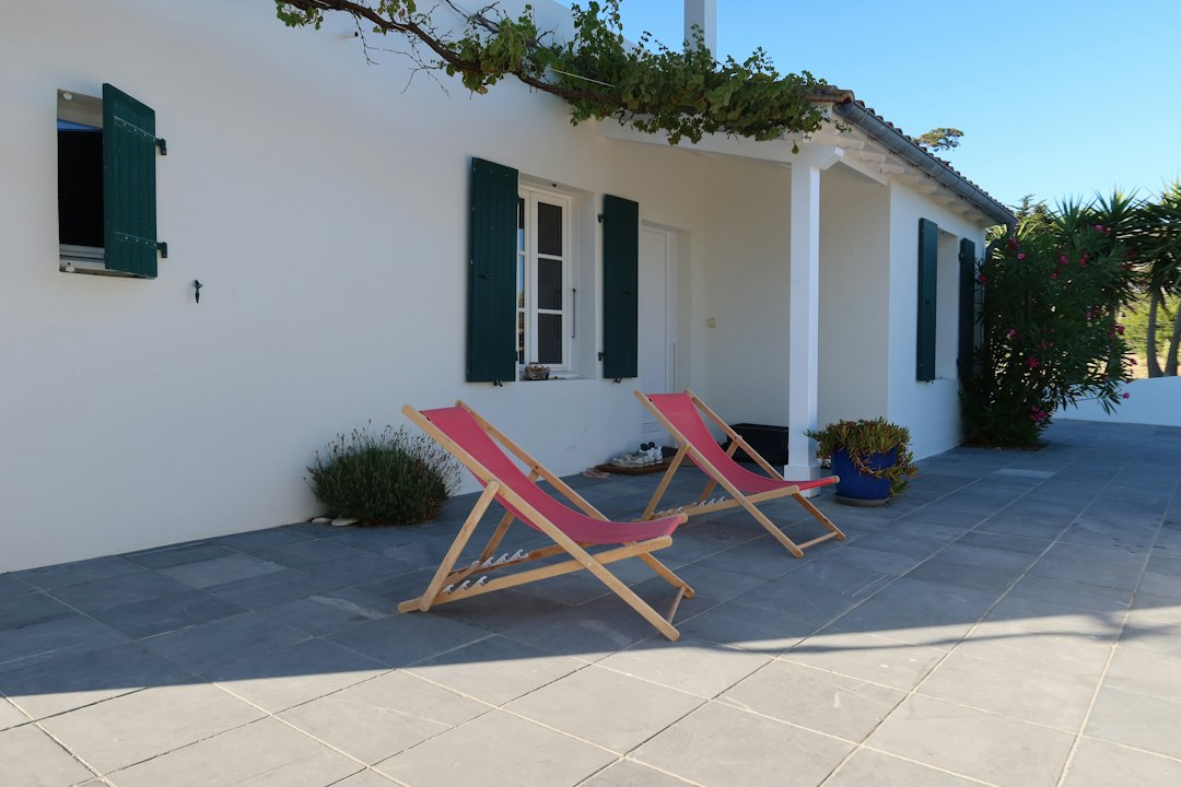 Terrasse fleurie d’une maison aux volets verts, illustration d’un bien immobilier pouvant être vendu libre ou occupé.